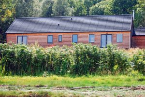 Larch clad cottage with grey uPVC windows & doors